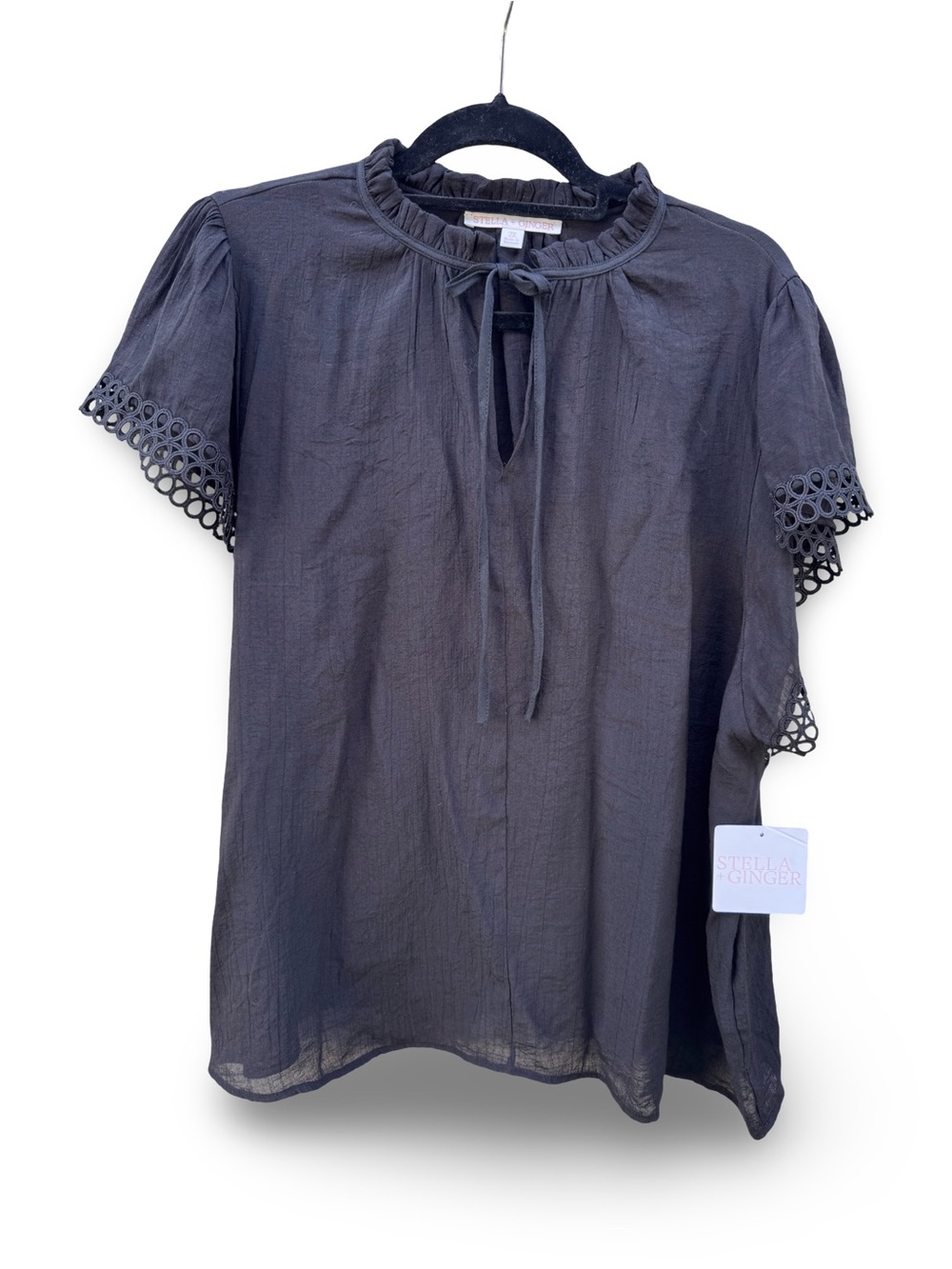 Black short-sleeved blouse with detailing on the sleeves.